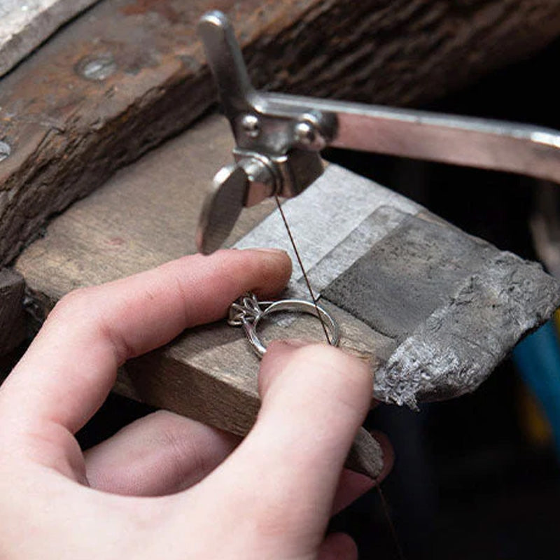 A gold ring under repair at the Sonny's bench